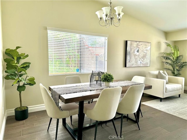 dining space with dark hardwood / wood-style floors, lofted ceiling, and a notable chandelier