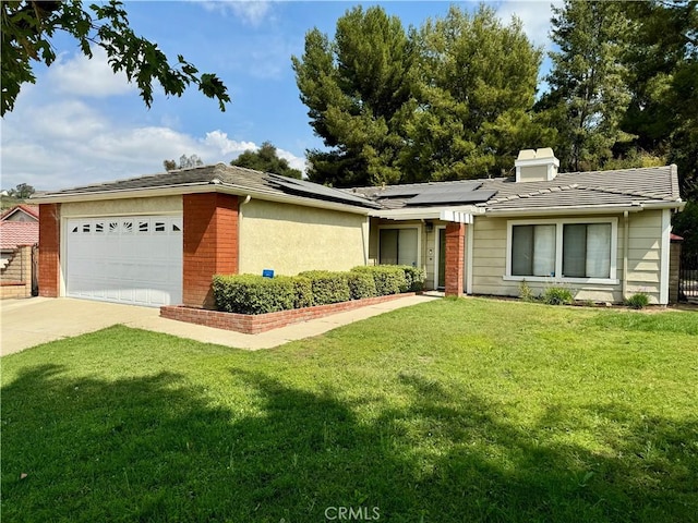 single story home featuring a garage, a front yard, and solar panels