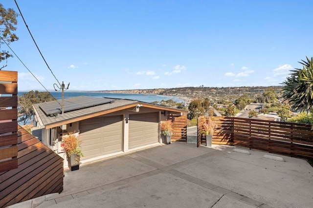 garage featuring solar panels and a water view