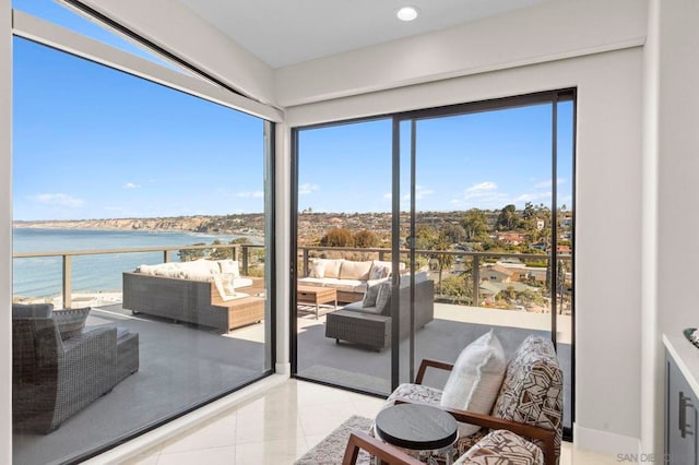 interior space with light tile patterned floors and a water view