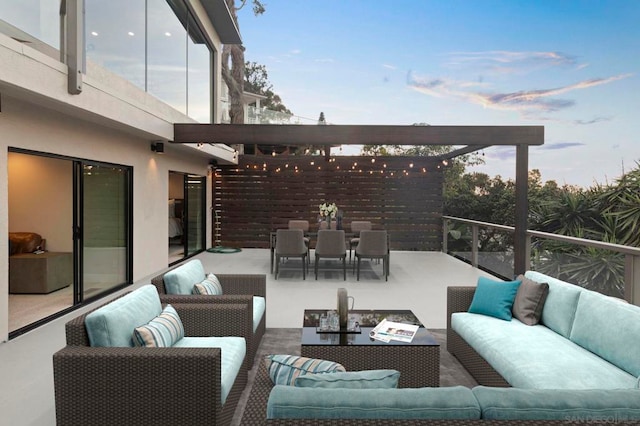 patio terrace at dusk featuring a balcony and an outdoor living space