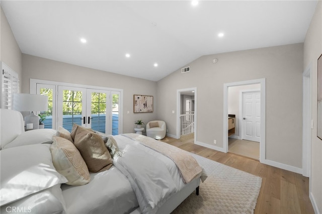 bedroom featuring lofted ceiling, french doors, access to exterior, light wood-type flooring, and connected bathroom