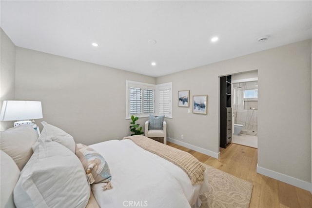 bedroom with light hardwood / wood-style flooring and ensuite bathroom