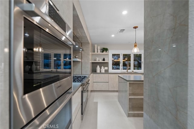 kitchen with stainless steel appliances, decorative light fixtures, white cabinetry, and sink