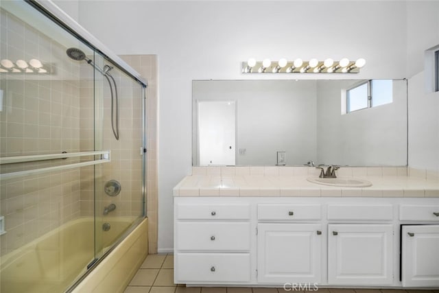 bathroom featuring tile patterned floors, vanity, and enclosed tub / shower combo