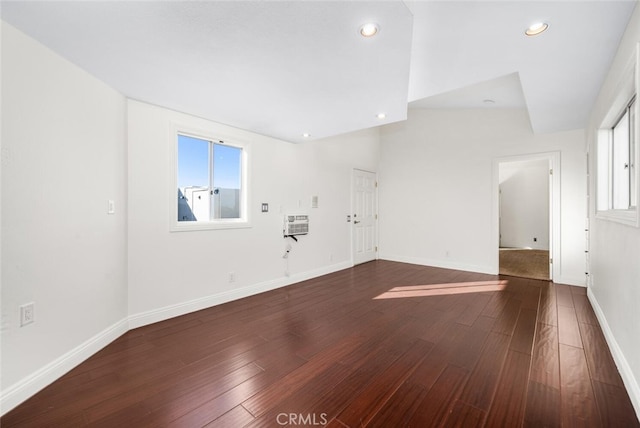 spare room featuring heating unit and dark hardwood / wood-style floors