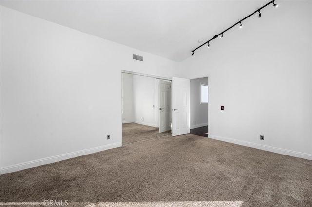 unfurnished bedroom with lofted ceiling, a closet, and carpet