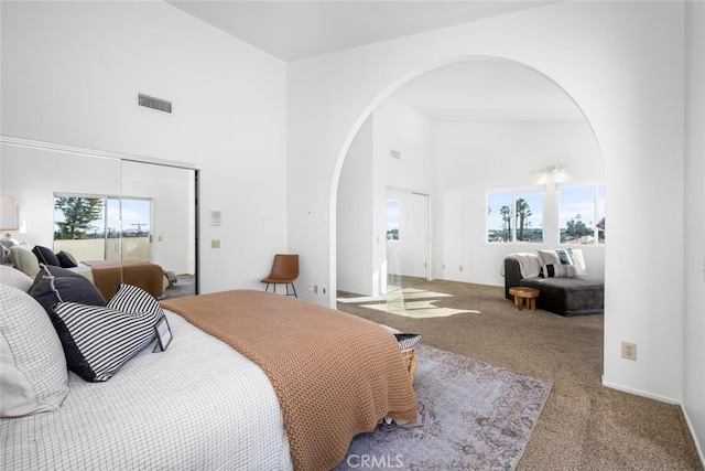 bedroom featuring a high ceiling and carpet floors