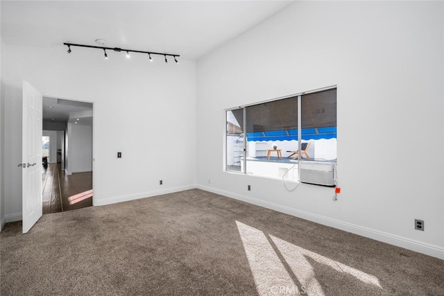 unfurnished room with carpet floors and rail lighting