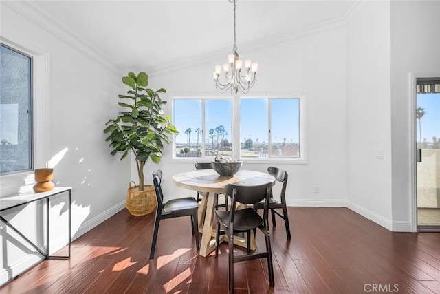 dining room with dark wood-type flooring, a notable chandelier, and crown molding