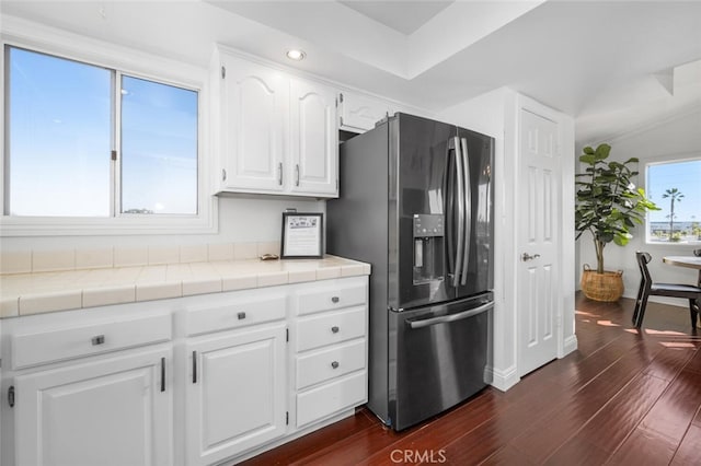 kitchen featuring white cabinets, stainless steel fridge, tile countertops, and dark hardwood / wood-style flooring