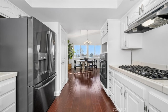 kitchen featuring a chandelier, appliances with stainless steel finishes, dark wood-type flooring, white cabinets, and decorative light fixtures