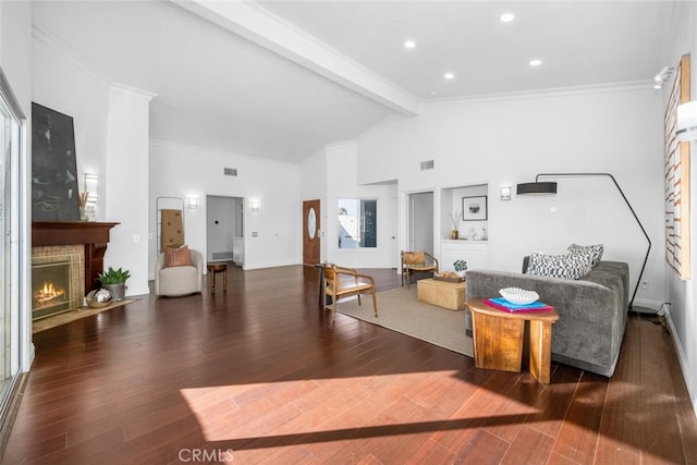 living room with a brick fireplace, ornamental molding, lofted ceiling with beams, and dark hardwood / wood-style floors