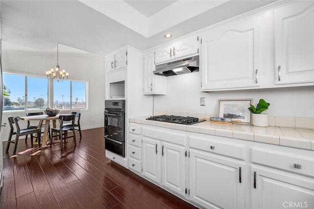 kitchen featuring black oven, tile counters, dark hardwood / wood-style floors, gas stovetop, and white cabinets