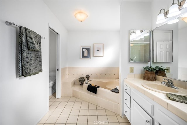 bathroom with a relaxing tiled tub, vanity, tile patterned floors, and toilet