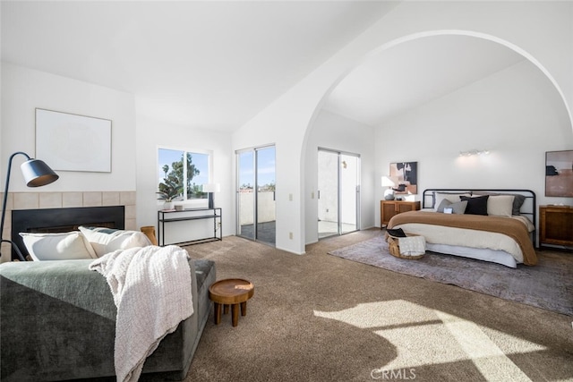 bedroom featuring high vaulted ceiling, a fireplace, and carpet floors