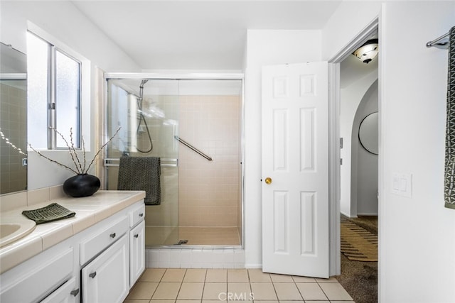 bathroom with tile patterned flooring, vanity, and a shower with shower door