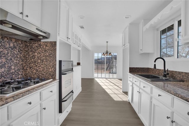 kitchen featuring sink, hanging light fixtures, white cabinets, and stainless steel gas stovetop