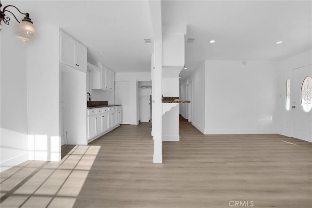 kitchen with white cabinets and light hardwood / wood-style flooring