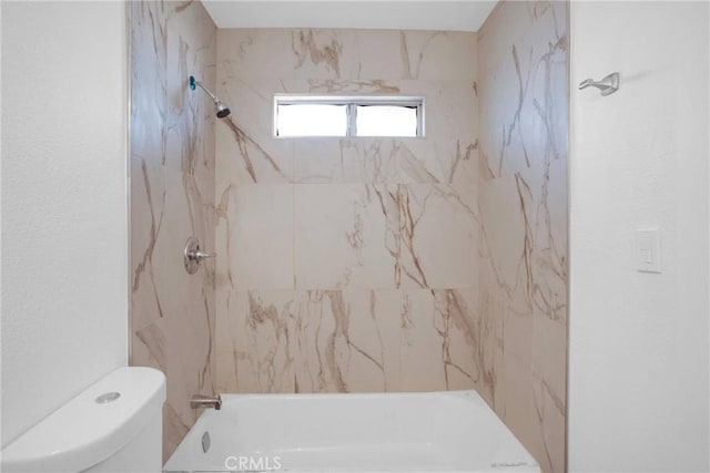 bathroom featuring toilet and tiled shower / bath combo