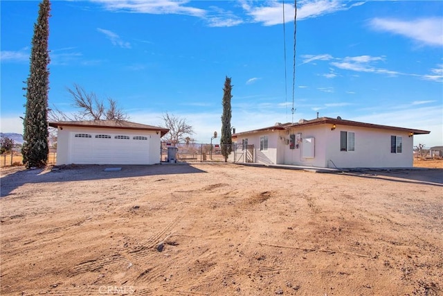 view of front of home featuring a garage and an outbuilding