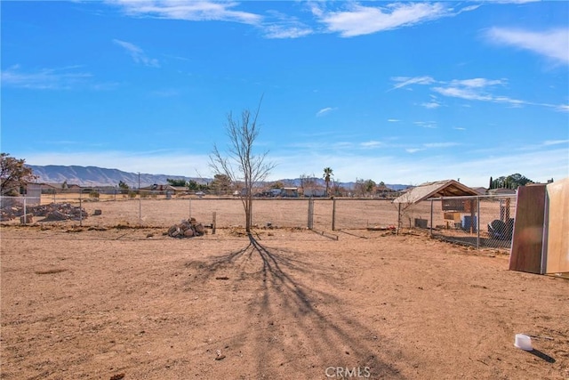 view of yard featuring a mountain view, a rural view, and an outdoor structure