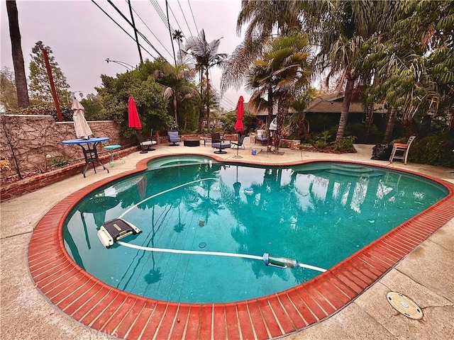 pool at dusk featuring a patio area