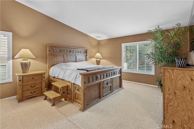 bedroom featuring lofted ceiling and light carpet