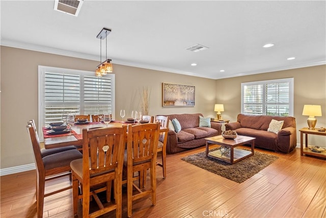 living room with ornamental molding and light hardwood / wood-style floors