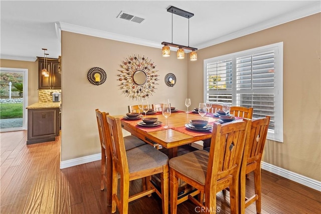 dining room with crown molding and hardwood / wood-style floors