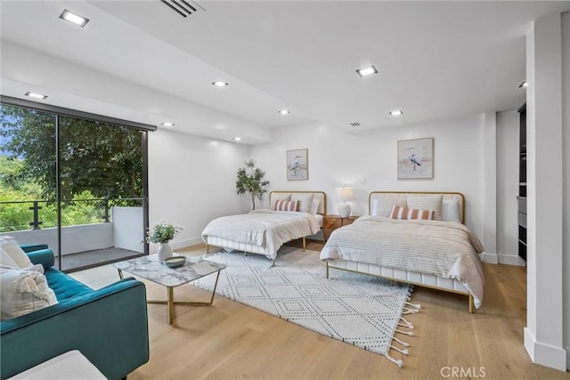 bedroom with access to exterior and light hardwood / wood-style flooring