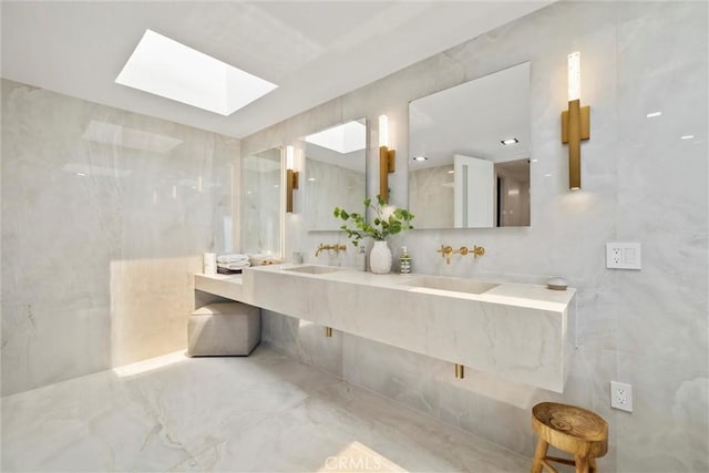 bathroom featuring vanity, a skylight, and tile walls