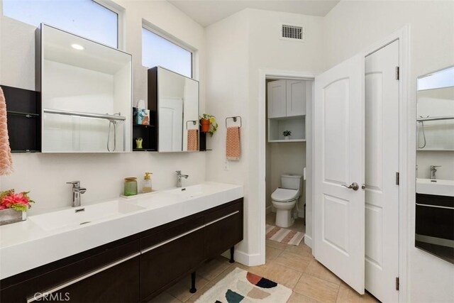 bathroom with toilet, an enclosed shower, tile patterned floors, and vanity