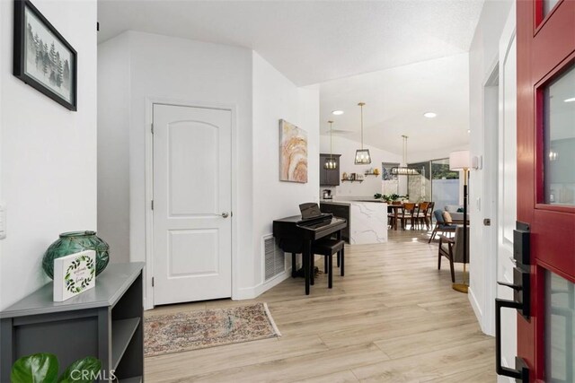 entryway featuring light hardwood / wood-style floors and vaulted ceiling