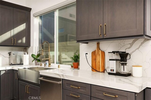 bar with light stone counters, stainless steel dishwasher, decorative backsplash, dark brown cabinets, and sink