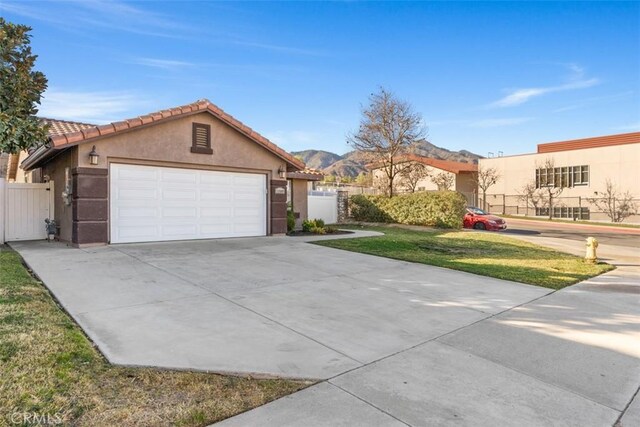 view of front of house with a mountain view, a front lawn, and a garage