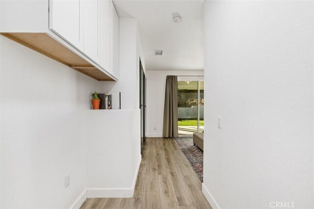 hallway with light hardwood / wood-style flooring