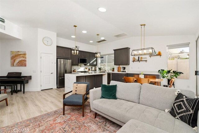 living room with lofted ceiling and light wood-type flooring