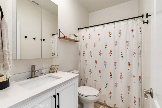 bathroom with walk in shower, vanity, and toilet