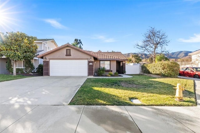 view of front of house with a front yard, a garage, and a mountain view