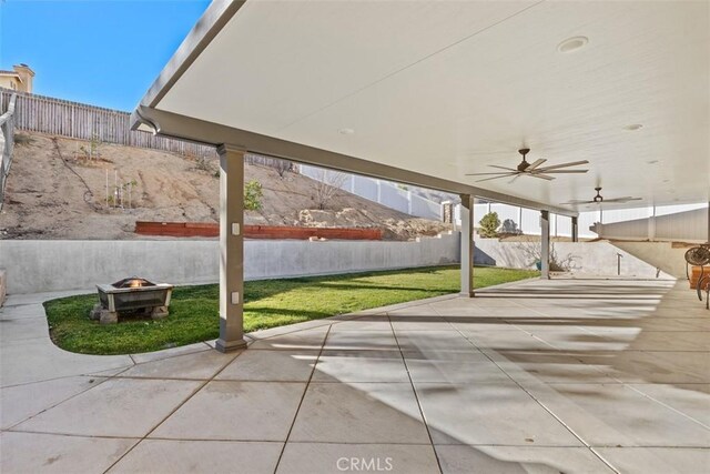 view of patio with ceiling fan and a fire pit