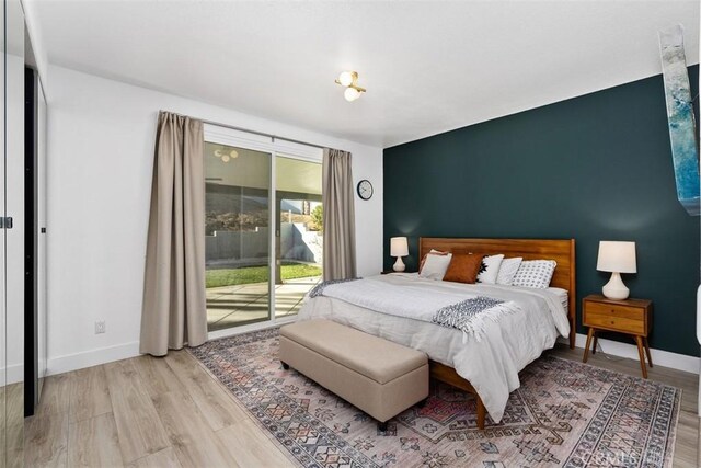 bedroom featuring access to exterior and light wood-type flooring