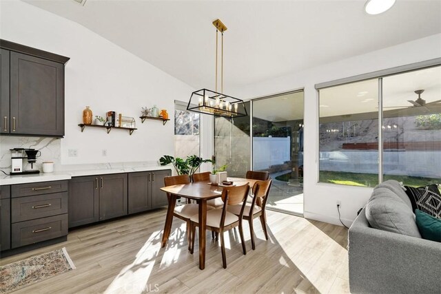 dining room featuring lofted ceiling, ceiling fan, and light hardwood / wood-style flooring