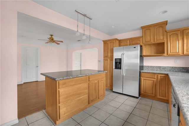 kitchen featuring ceiling fan, a kitchen island, appliances with stainless steel finishes, light tile patterned floors, and rail lighting