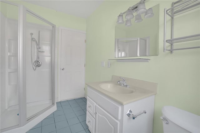 bathroom with a shower with shower door, toilet, vanity, and tile patterned flooring