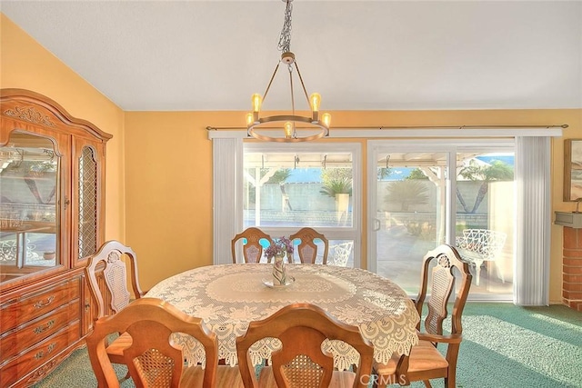 dining room featuring carpet, a chandelier, and lofted ceiling