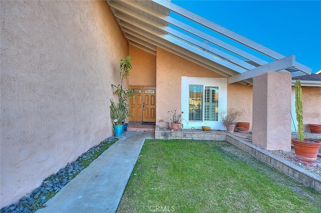 doorway to property featuring a lawn