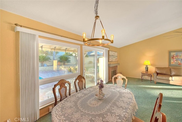 carpeted dining room featuring vaulted ceiling and ceiling fan with notable chandelier