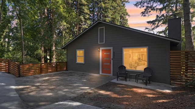 back house at dusk featuring a patio area