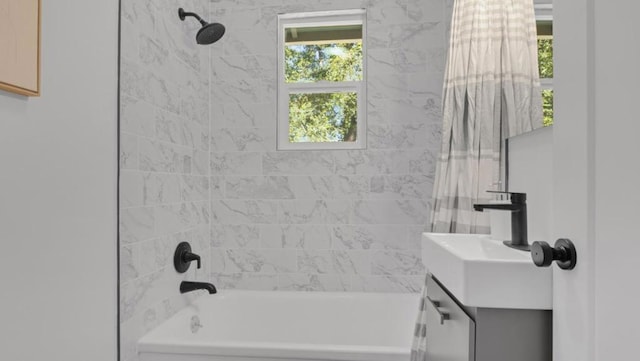 bathroom featuring vanity and tiled shower / bath